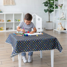 Load image into Gallery viewer, A child draws at a small table covered with a Bumkins Splat Mat: Super Mario™ Lineup  in a bright living room.
