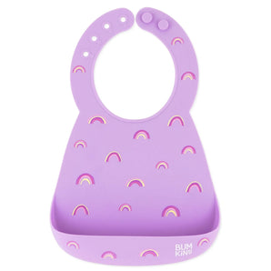 Bumkins Silicone Bib: Rainbows features a purple silicone bib with rainbow patterns, a pocket, and adjustable neck closure.