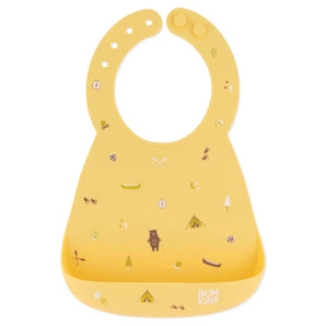 Bumkins Silicone Bib: Camp Gear features a camping design with tents, trees, and bears on yellow silicone, with a front pocket.