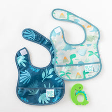 Load image into Gallery viewer, Bumkins Starter Bib 2 Pack: Dinosaurs &amp; Blue Tropic lays on a white background next to a dinosaur-shaped teether.
