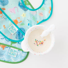 Load image into Gallery viewer, A bowl of yogurt with sprinkles sits beside Bumkins Starter Bib 2 Pack: Ocean Life &amp; Whale Tail on a white background.
