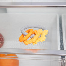 Load image into Gallery viewer, Close-up of Bumkins Silicone Teething Charms: Orange inside a refrigerator.

