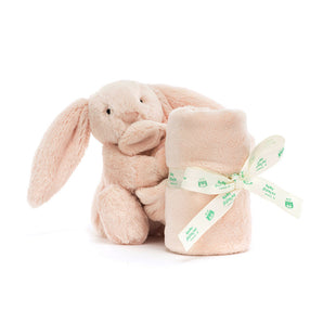 A blush-pink Jellycat Soother Bashful Bunny holding a soft lovey blanket tied with a matching branded ribbon.