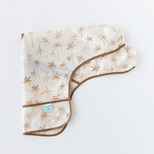 Load image into Gallery viewer, Bumkins Sleeved Bib: Palm Daze is folded lengthwise on a white background.
