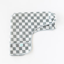 Load image into Gallery viewer, Bumkins Sleeved Bib: Charcoal Check lays folded lengthwise on a white background.
