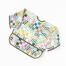 Load image into Gallery viewer, Bumkins Sleeved Bib: Motley Check rests on a white background.
