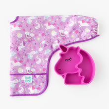 Load image into Gallery viewer, Bumkins Silicone Grip Dish Special Edition: Unicorn rests next to a folded unicorn patterned bib on a white background.
