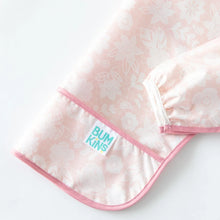 Load image into Gallery viewer, Close-up of Bumkins Sleeved Bib: Lace folded on a white background, with focus on the front pocket and white elastic cuff on the sleeves.

