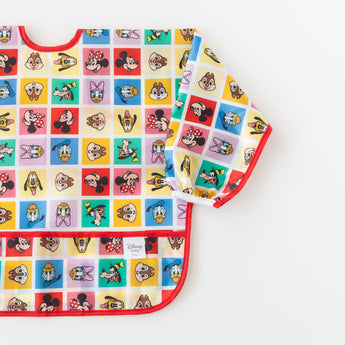 Bumkins Sleeved Bib: Mickey & Friends Check Mates is shown flat on a white background.