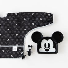 Load image into Gallery viewer, Bumkins Sleeved Bib: Mickey Mouse Icon Black + White lays flat next to a Mickey Mouse-shaped plate &amp; matching utensils on a white background.

