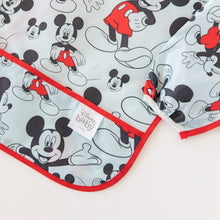 Load image into Gallery viewer, Close-up of Bumkins Sleeved Bib: Mickey Mouse laid flat on a white background, with focus on the front pocket.
