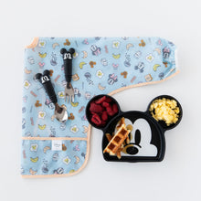 Load image into Gallery viewer, Bumkins Sleeved Bib: Mickey + Minnie Sunny Side Up is folded on a white background next to a Mickey-shaped plate and matching utensils.
