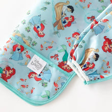 Load image into Gallery viewer, Close-up of Bumkins Sleeved Bib: Ariel folded on a white background, with focus on the front pocket and elastic cuff on the sleeves. 
