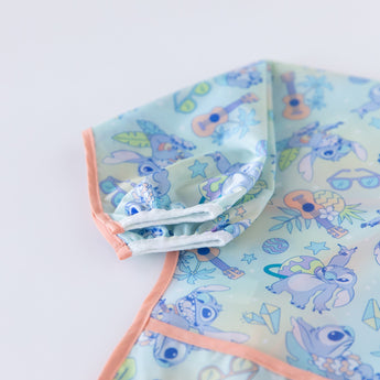 Close-up of Bumkins Sleeved Bib: Aloha Stitch on a white background, highlighting the white elastic cuff on the sleeve.