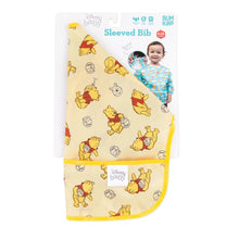 Load image into Gallery viewer, Bumkins Sleeved Bib: Winnie Loves Hunny is shown folded in its packaging.
