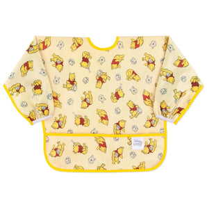 Bumkins Sleeved Bib: Winnie Loves Hunny features yellow waterproof fabric with playful Winnie the Pooh illustrations and a front pocket.