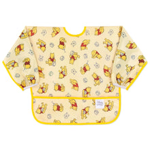 Load image into Gallery viewer, Bumkins Sleeved Bib: Winnie Loves Hunny features yellow waterproof fabric with playful Winnie the Pooh illustrations and a front pocket.
