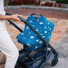 Load image into Gallery viewer, A person pushes a stroller with a Milk Snob Cover Star Wars the Child along a paved path.
