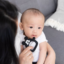 Load image into Gallery viewer, Close-up of a woman holding a baby, placing a Bumkins Silicone Flat Teether: Mickey Mouse near their mouth.

