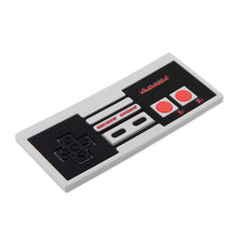 Load image into Gallery viewer, Bumkins Silicone Teether: NES™ Controller is a gray and black retro-style food-safe silicone teether modeled after a video game controller.
