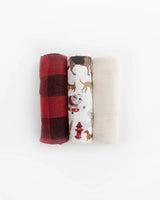 The Little Unicorn Cotton Swaddle Set, Woof features three swaddles: red plaid, dog-patterned white, and solid cream on a white background.