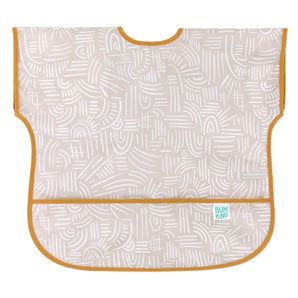 Bumkins Junior: Bib Wander features beige waterproof fabric with abstract white patterns, orange trim, and a catch-all pocket.