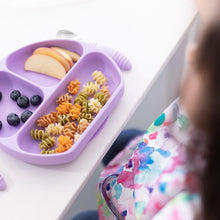 Load image into Gallery viewer, A child enjoys spiral pasta, apple slices, and blueberries from a purple divided plate, wearing a Bumkins Junior Bib: Watercolor.
