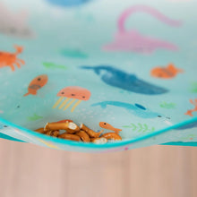 Load image into Gallery viewer, Close-up of pretzels in the pocket of a Bumkins Junior Bib: Ocean Life.
