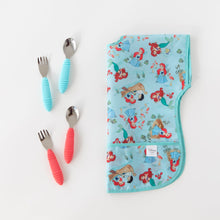 Load image into Gallery viewer, Bumkins Junior Bib: Ariel lays folded next to two sets of utensils in blue and red on a white background.
