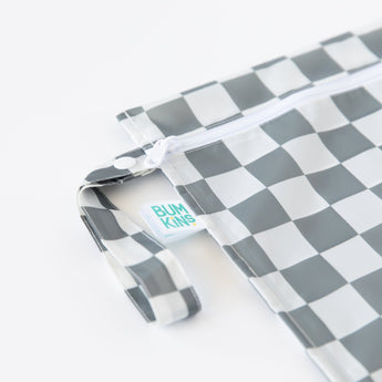 Close-up of Bumkins Wet Bag: Charcoal Check on a white background, with focus on the side handle, zipper, and logo tag.