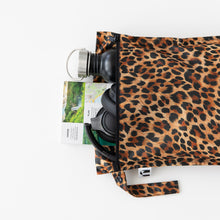 Load image into Gallery viewer, Roamio by Bumkins Wet Bag: Leopard lays horizontally with a water bottle, headphones, and trail map peeking out on a white background.
