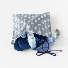Load image into Gallery viewer, Bumkins Wet Bag: Arrow rests on a white background with flip-flops, a swimsuit, hair clip, and sunscreen inside.
