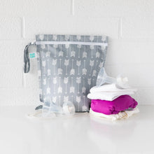 Load image into Gallery viewer, Bumkins Wet Bag: Arrow sits against a white wall on a white table with cloth diapers and breast pump parts in front.
