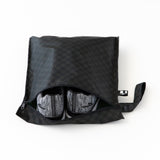 Roamio by Bumkins Wet Bag: Rich Black holds gray sneakers on a white background.
