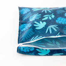 Load image into Gallery viewer, Bumkins Wet Bag: Blue Tropic lays partially open on a white background, revealing the interior.
