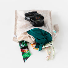 Load image into Gallery viewer, Bumkins Wet Bag: Wander lays open on a white background with swimsuit &amp; clothes inside; a black fan lays on top.
