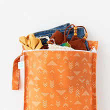 Load image into Gallery viewer, Bumkins Wet Bag: Grounded holds clothes and swimwear on a white background.
