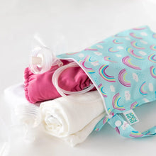 Load image into Gallery viewer, Bumkins Wet Bag: Rainbows stores cloth diapers, breast pump parts, and a towel on a white background.
