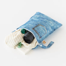 Load image into Gallery viewer, Bumkins Wet Bag: Vintage Denim lays open on a white background with a sweater, thermos, and book inside.
