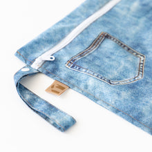 Load image into Gallery viewer, Close-up of Roamio by Bumkins Wet Bag: Vintage Denim on a white background, with focus on the zipper and side handle.
