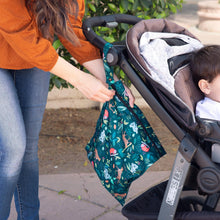 Load image into Gallery viewer, A woman unzips a Bumkins Wet Bag: Jungle to a stroller near some foliage as she strolls outside with her child.
