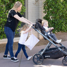 Load image into Gallery viewer, A woman and child push a toddler in a stroller outside by greenery, with a Bumkins Wet Bag: Lace hanging from the handle.
