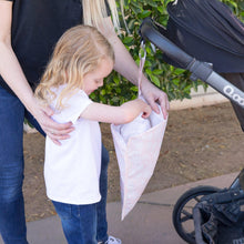 Load image into Gallery viewer, A child puts an item into a Bumkins Wet Bag: Lace attached to a stroller outdoors with an adult nearby.
