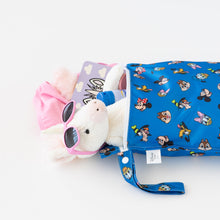 Load image into Gallery viewer, A plush toy in sunglasses peeks from a Bumkins Wet Bag: Mickey &amp; Friends Forever, next to a pink garment and purple book on a white table.
