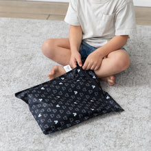 Load image into Gallery viewer, A boy unzips a Bumkins Wet Bag: Mickey Mouse Icon Black + White while sitting on a gray rug.
