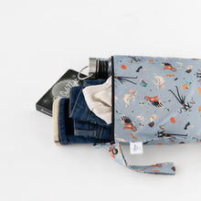 Load image into Gallery viewer, Bumkins Wet Bag: No Tricks, Just Treats holds jeans, a white shirt, thermos, and book on a white background.
