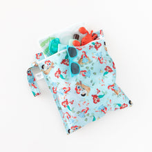 Load image into Gallery viewer, Bumkins Wet Bag: Disney Princess Ariel holds sunscreen, goggles, sunglasses, and sand toys on a white background.
