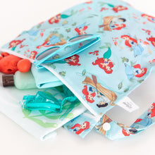 Load image into Gallery viewer, Close-up of Bumkins Wet Bag: Disney Princess Ariel on a white background, filled with goggles, sunglasses, and swimwear.
