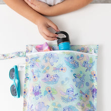 Load image into Gallery viewer, A child grabs a blue bottle from a Bumkins Wet Bag: Aloha Stitch on a white table with sunglasses nearby.
