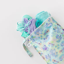 Load image into Gallery viewer, A towel, swimwear, and goggles peek out of Bumkins Wet Bag: Aloha Stitch on a white background.
